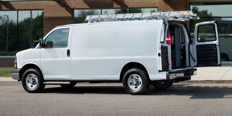 2021 Chevy Express cargo van with ladder on top and rear door open