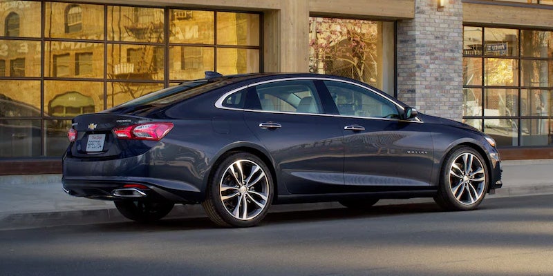 rear angle view of a 2022 Chevrolet Malibu parked in front of building