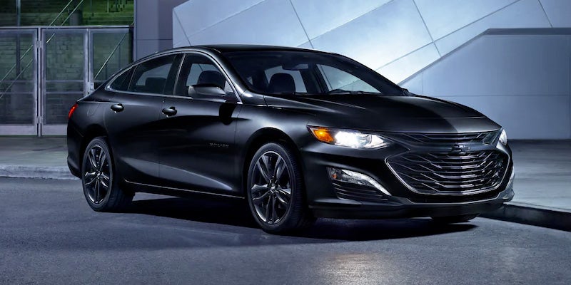 black 2022 Chevrolet Malibu with headlights on