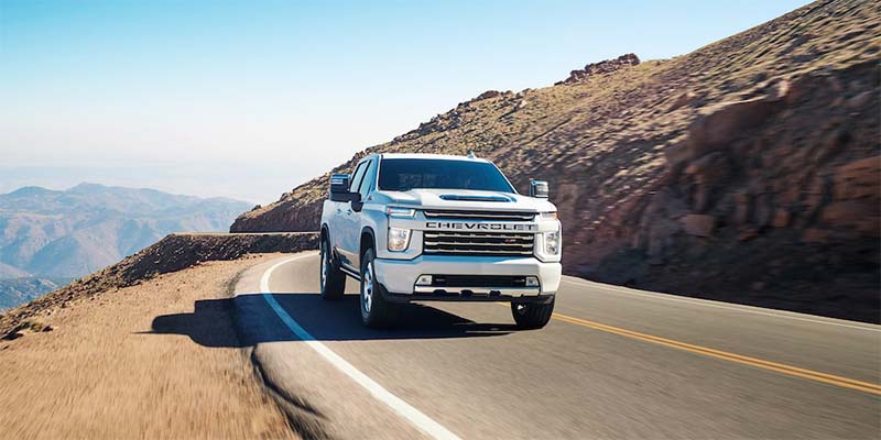 White 2023 Chevrolet Silverado HD driving on road