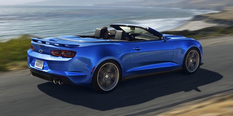 View from the back of a blue 2024 Chevrolet Camaro driving on road with the top down