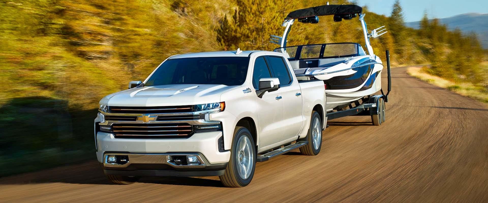 Chevy Silverado in white towing a boat