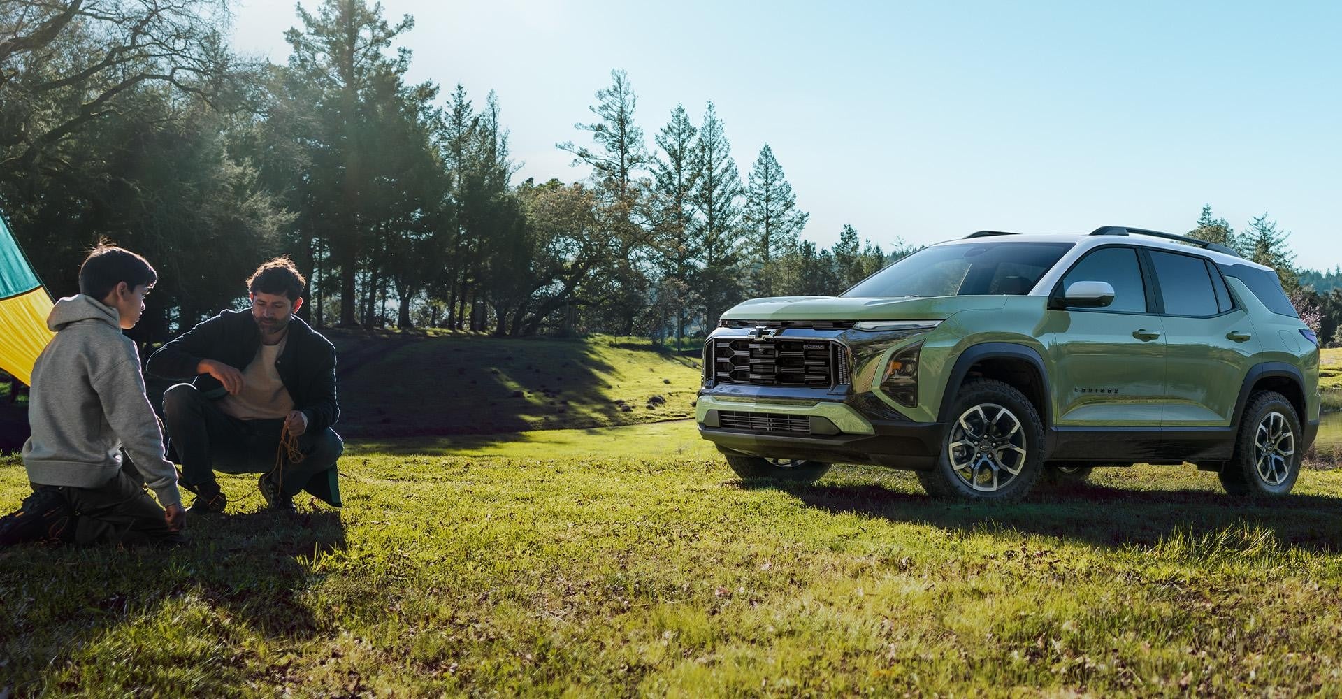 People camping in a tent around a Chevy Equinox