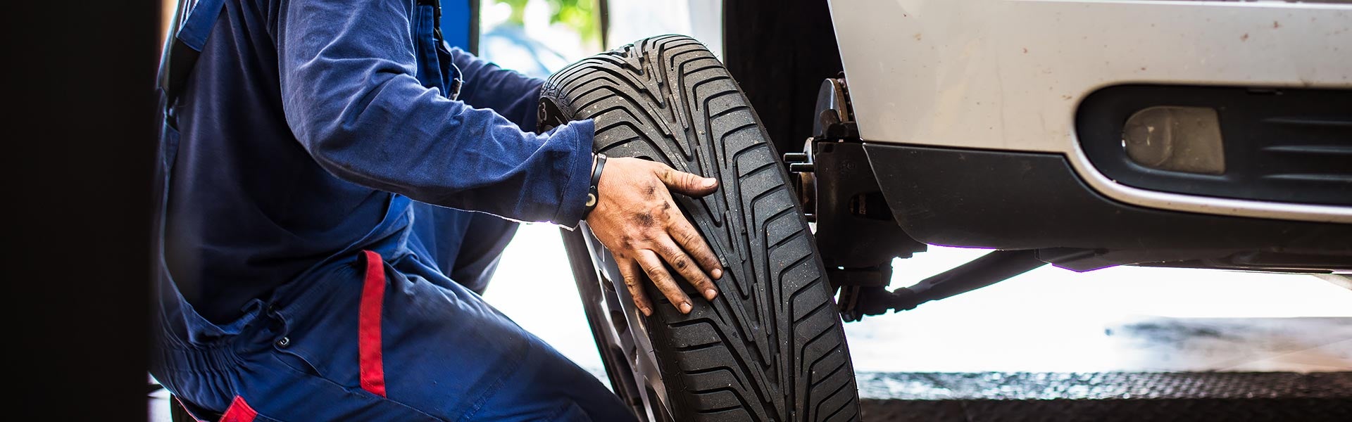 Mechanic putting tire on vehicle